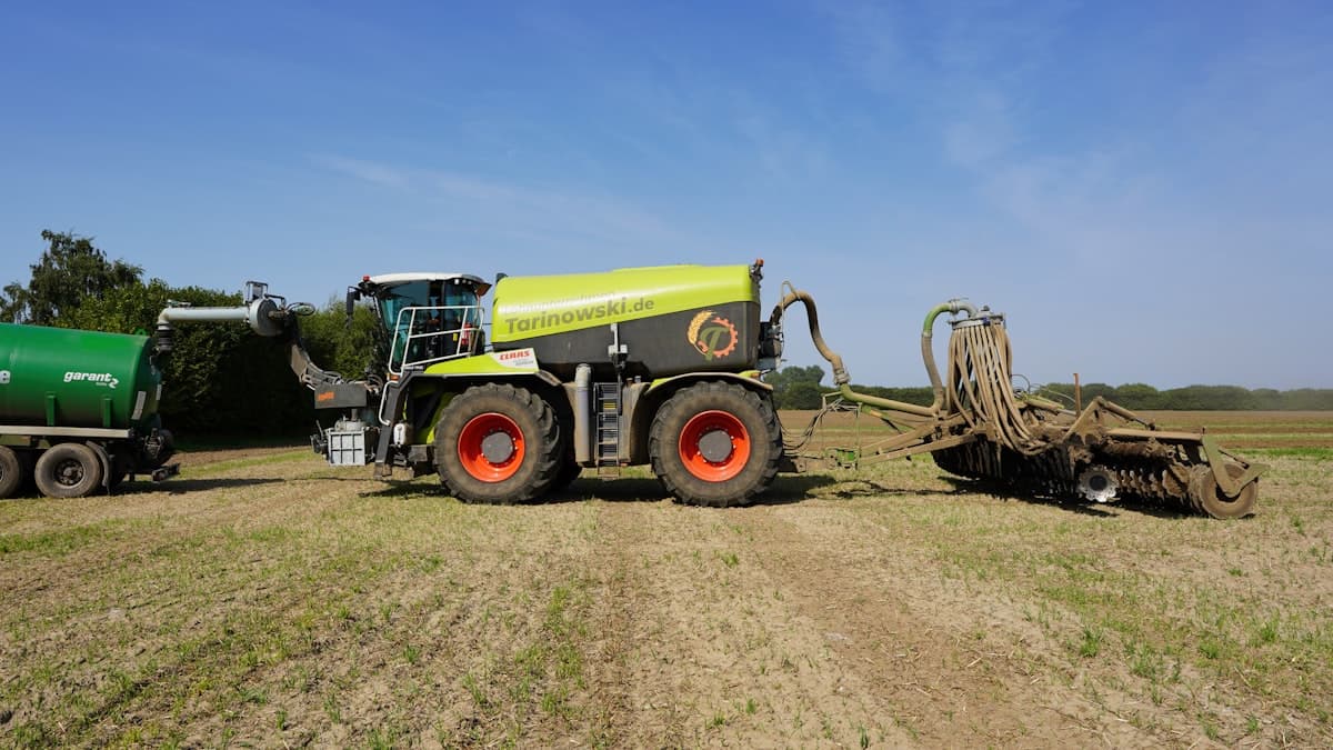 Self-propelled slurry tanker with trailing-hose manure applicator working a field
